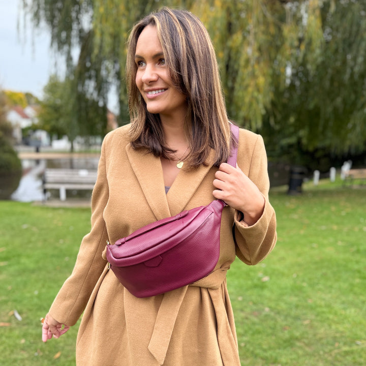 Women in beige coat wearing Burgundy purse