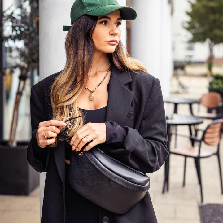 a person wearing a black leather waist bag