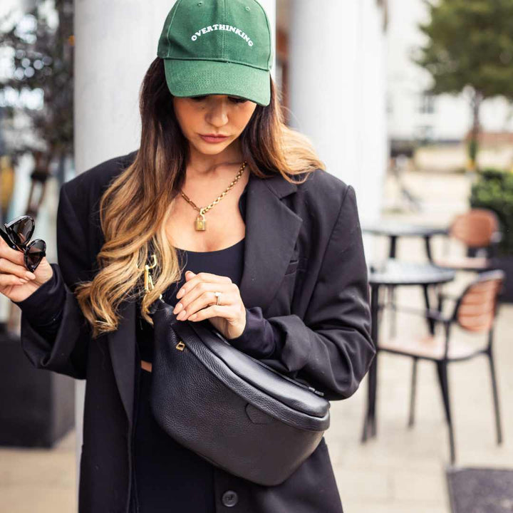 a person wearing a black leather bumbag