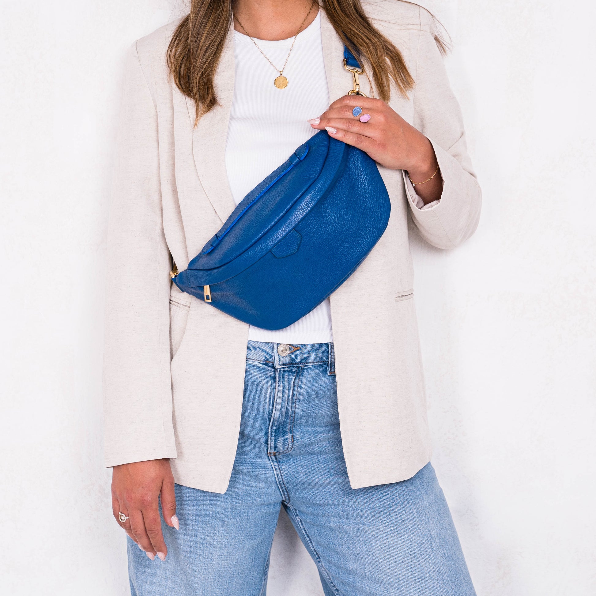 Person wearing a blue waist bag with a plain background