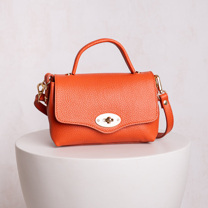 Orange leather handbag with a gold clasp 