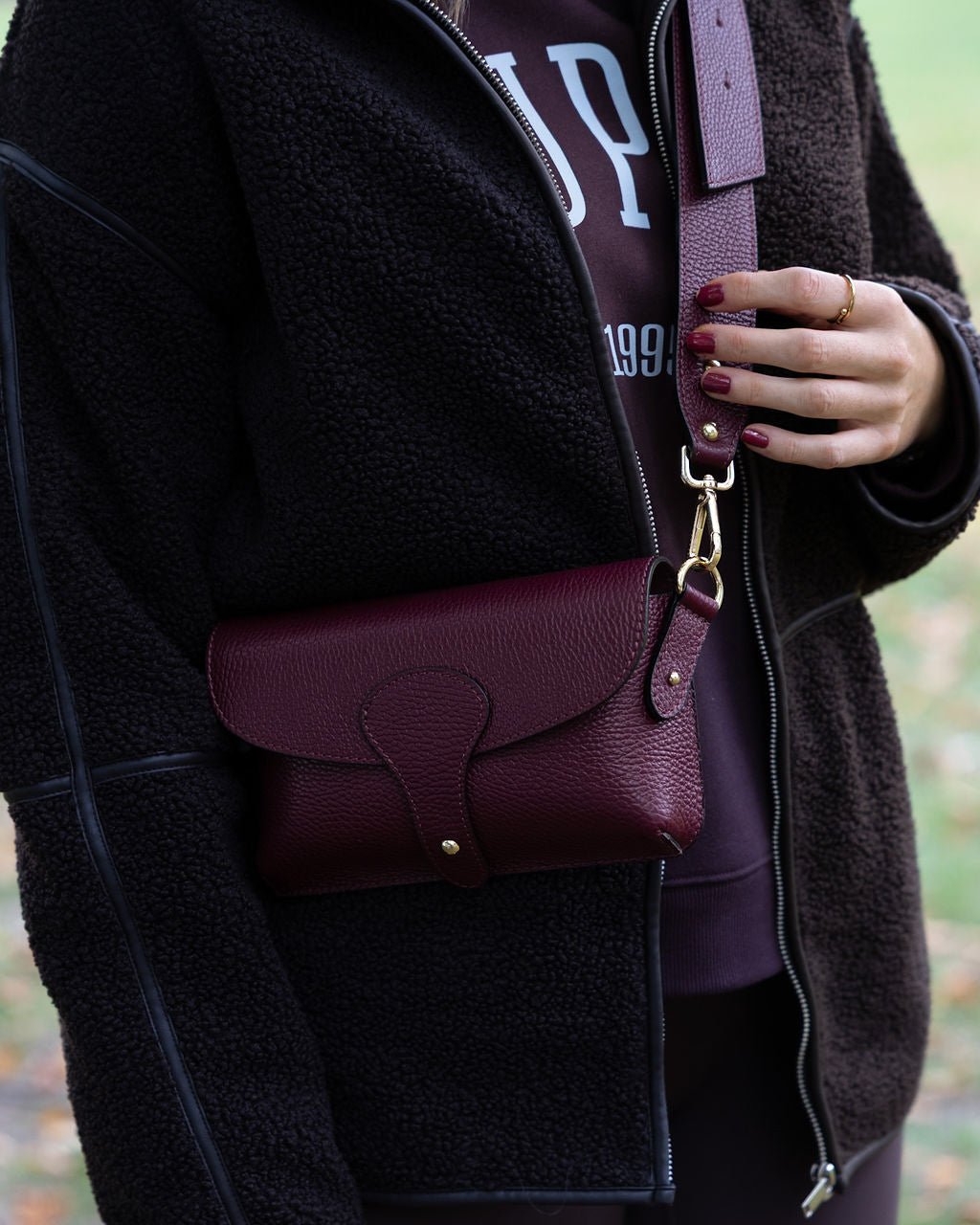 leather burgundy crossbody worn over shoulder 